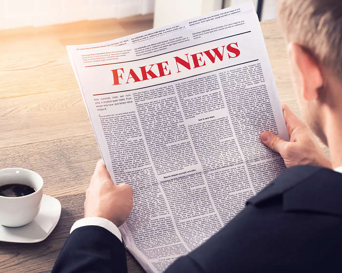 Persona leyendo "fake news" en un periódico